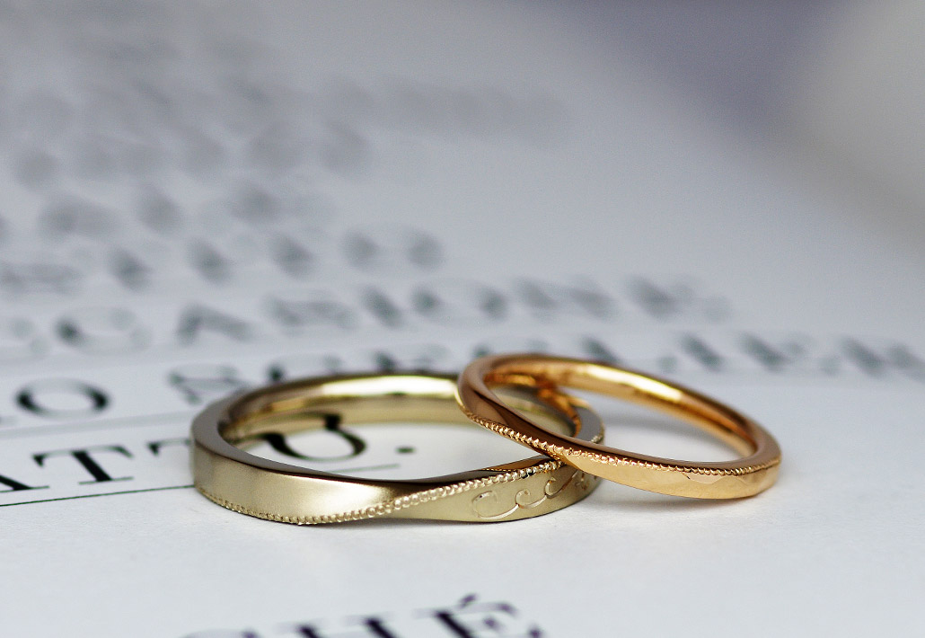 ミルグレインが斜めに入ったブラウンゴールドとピンクゴールドのひねりデザインの結婚指輪（マリッジリング）
